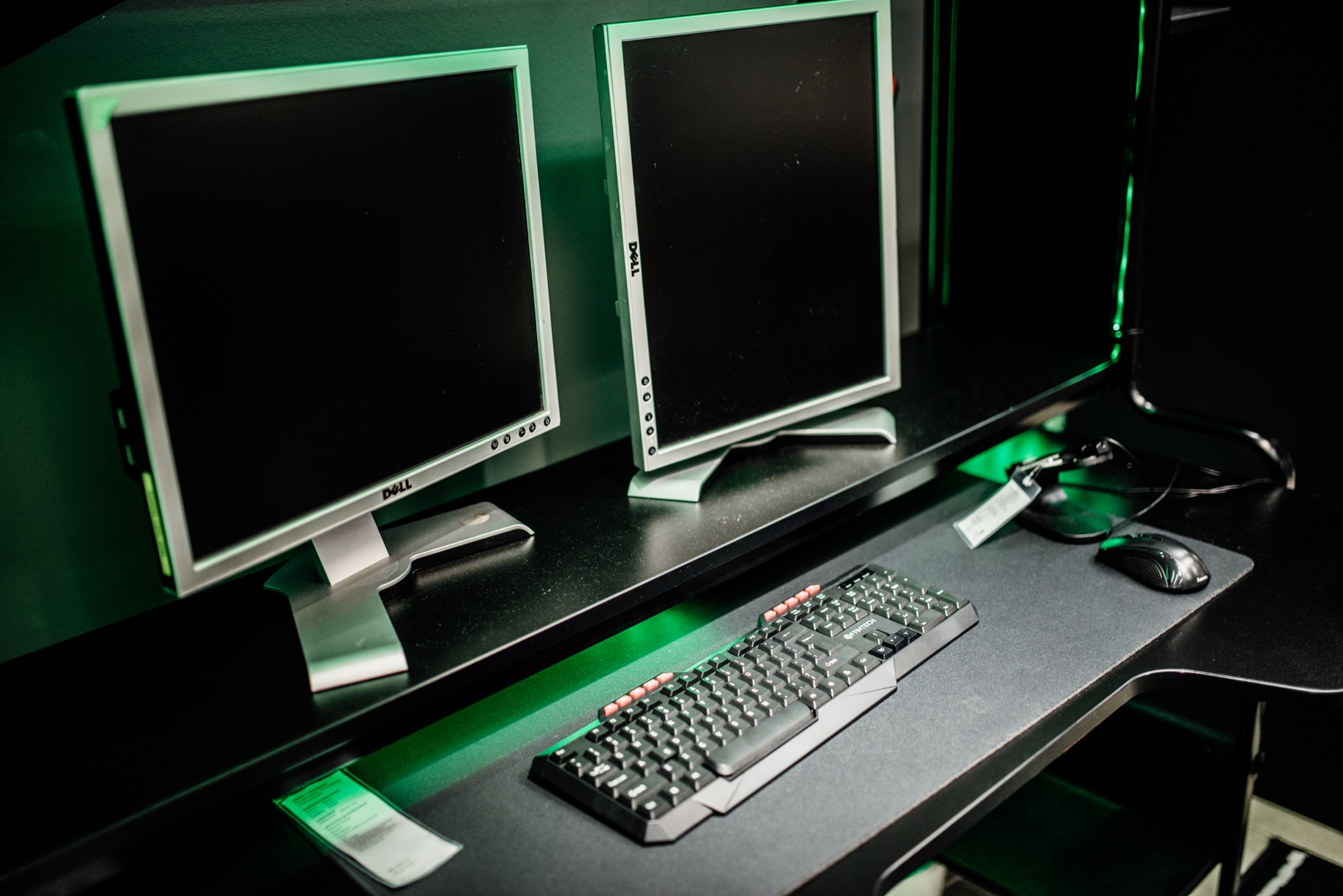 Poste de gaming avec deux écrans, clavier et souris, dans une pièce à l'éclairage tamisé